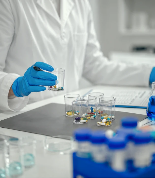 Pharmaceutical scientist assessing capsule and tablet samples in a laboratory